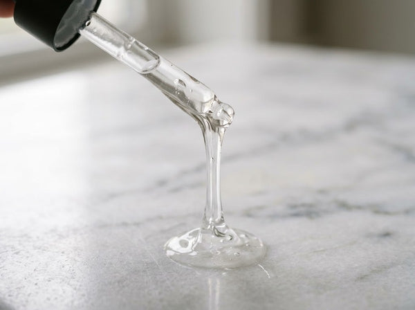 Clear stretchy snail mucin essence texture on a dropper